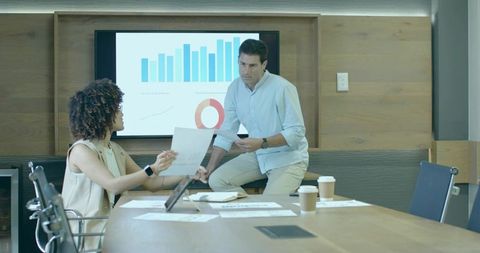 Business Professionals Analyzing Reports in Modern Boardroom