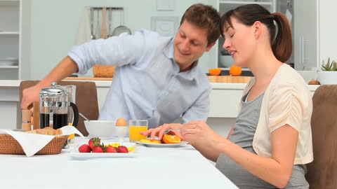 Expectant Couple Enjoying Breakfast at Home