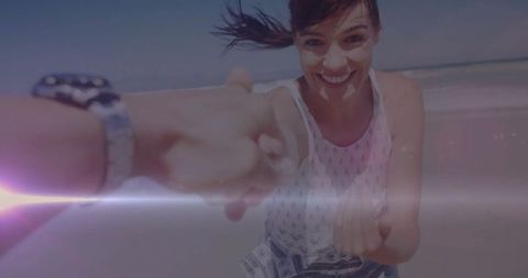 Joyful woman in sundress holding hand on beach adventure
