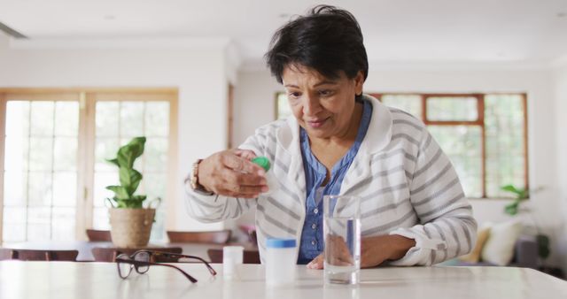 Asian senior woman checking her medicine containers in the living room at home. retirement lifestyle and living concept