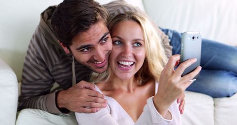 Smiling Couple Capturing Joyful Selfie in Cozy Living Room