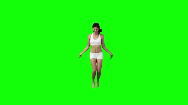 Woman working out with skipping rope against green background. Useful for fitness tutorials, workout promotions, or healthy lifestyle blogs. Ideal for creating engaging content focused on physical activity and sport.