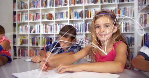 Smiling girl writing in library classroom with classmates collaborating on homework