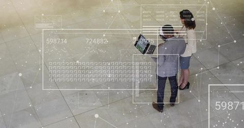 Professionals analyzing interactive data overlays in modern atrium
