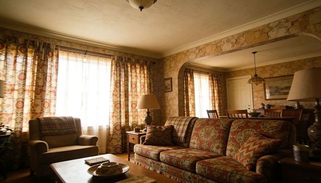 Vintage patterned sofa anchoring cozy traditional living room with warm lighting