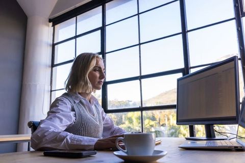 Executive Woman Working With Laptop in Modern Office With Natural Light