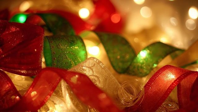 Festive Glowing Ribbons with Warm String Lights, Bokeh Sparkle and Holiday Bows Close-up