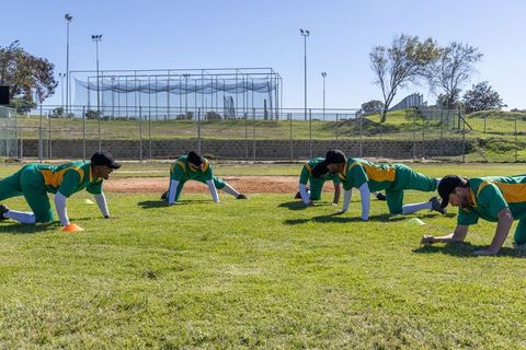 Baseball team stretching on outfield grass before game