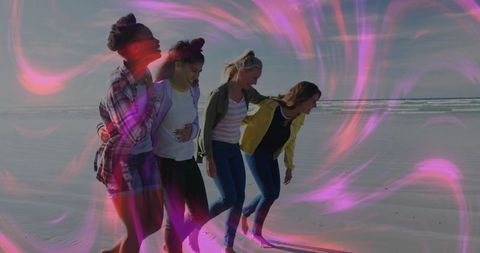 Friends walking on beach with ethereal pink glow