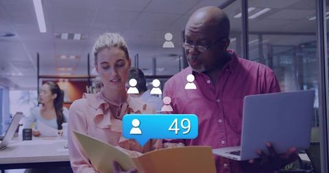 Colleagues collaborating over documents and laptop with social follower notification overlay