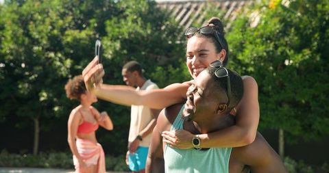 Diverse Friends Taking Piggyback Selfie in Sunny Garden