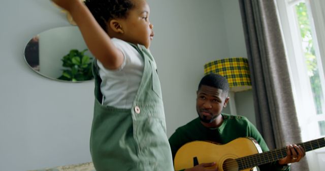 Happy father and son spending time together, playing guitar and jumping - Download Free Stock Images Pikwizard.com