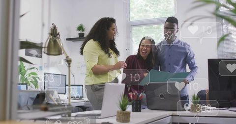 Multicultural team collaborating over teal folder in office with laptops and digital overlays