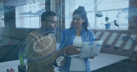 Collaborative Colleagues Analyzing Data on Laptop in Modern Office