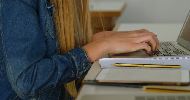 Student in Denim Jacket Typing on Laptop at Desk - Download Free Stock Images Pikwizard.com