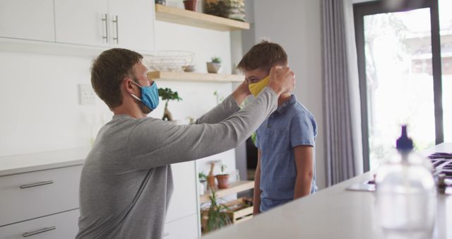 Father Helping Son Wear Protective Face Mask in Modern Kitchen - Download Free Stock Images Pikwizard.com