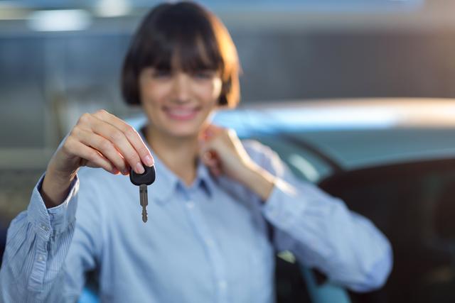 Customer holding a car key in repair garage