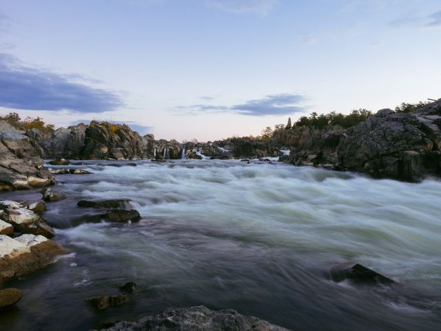Capturing the serene beauty of a river flowing through a rocky landscape at dusk. Perfect for nature-themed projects, travel blogs, or backgrounds needing a calming and natural vibe.