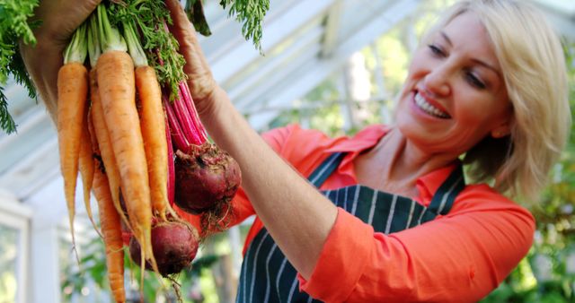 Woman Holding Freshly Harvested Vegetables in a Greenhouse - Download Free Stock Images Pikwizard.com