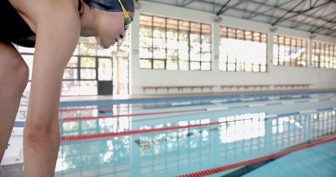 Competitive swimmer preparing for dive in indoor pool