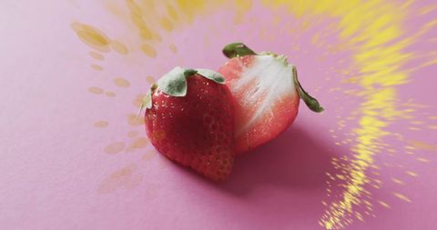 Fresh strawberries with vibrant splash effect on pink background