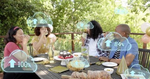 Friends celebrating on deck sipping drinks and sharing dessert with cloud overlays