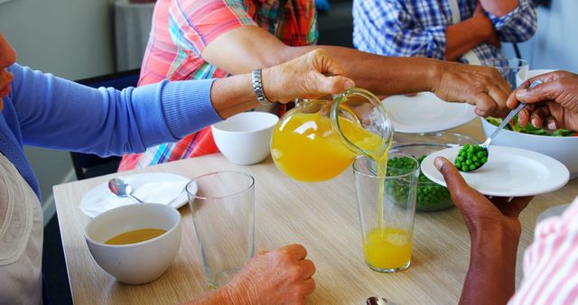 Senior People Enjoying Meal Together with Orange Juice and Vegetables - Download Free Stock Images Pikwizard.com