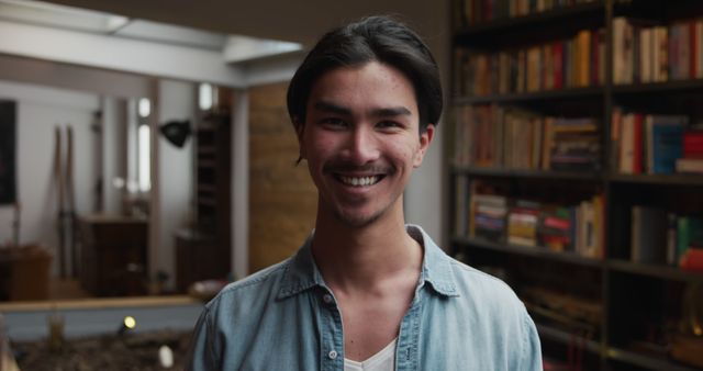 Smiling young man in home library setting - Download Free Stock Images Pikwizard.com