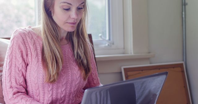 Woman Working on Laptop at Home in Pink Sweater - Download Free Stock Images Pikwizard.com