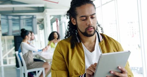 Young Professional Using Tablet in Modern Office