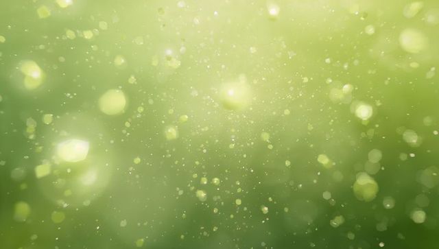 Floating green bokeh particles drifting with soft glows and light orbs