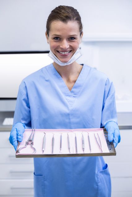 Smiling Dental Assistant Holding Tray with Dental Tools - Download Free Stock Photos Pikwizard.com