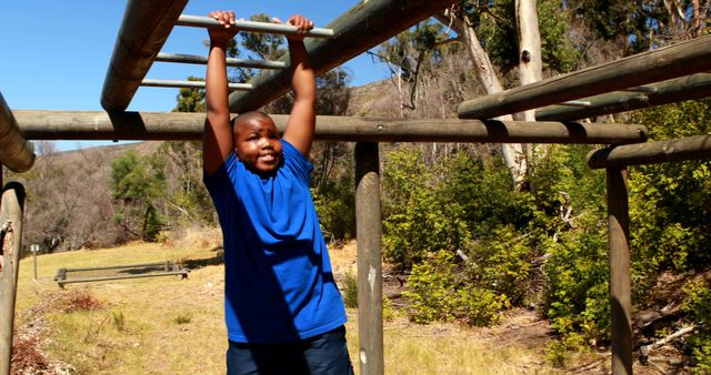 An African American boy is engaging in outdoor physical activity on monkey bars, with copy space - Download Free Stock Photos Pikwizard.com