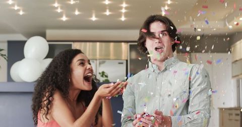 Joyful Couple Celebrating with Confetti in Living Room