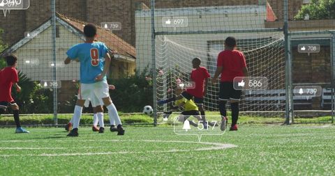 Youth soccer game with diving goalkeeper on vibrant turf