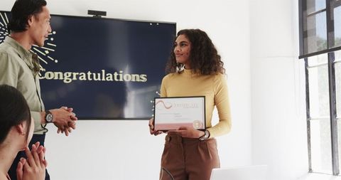Colleagues celebrating achievement at certification ceremony in modern office