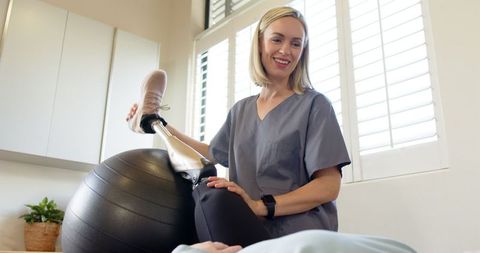 Physical therapist assisting patient with prosthetic leg