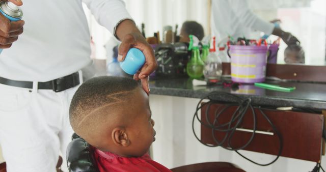 Barber creating stylish unique haircut for young boy. Ideal for men’s grooming promotions, barber training material, hair product advertisements.