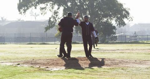 Male Athletes Celebrating on Baseball Field Mound