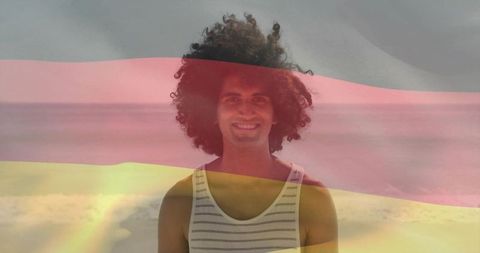 Smiling man on beach with tricolor overlay, casual striped tank portrait