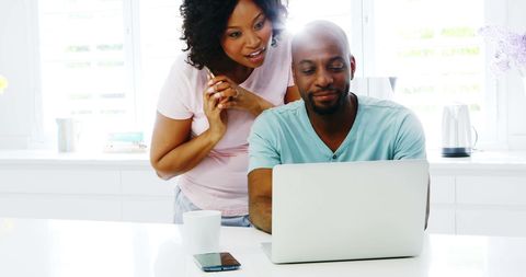 Happy Couple Collaborates in Modern Home on Laptop Activity