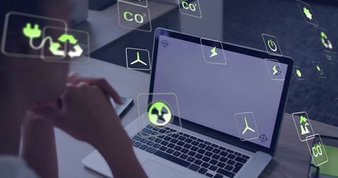 Analyzing renewable energy metrics on laptop with floating green sustainability icons