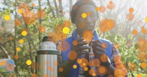 Man relaxing with hot drink in peaceful forest setting