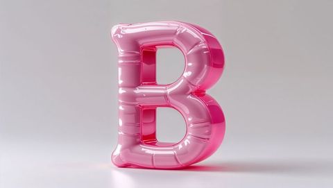 Shiny metallic pink letter b balloon on soft surface