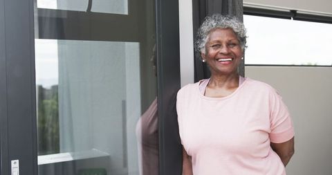 Smiling Senior African American Woman at Home by Large Window