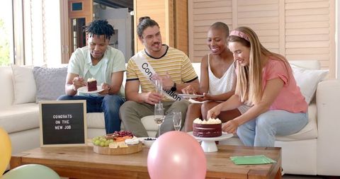 Diverse Friends Celebrating New Job with Cake in Cozy Living Room