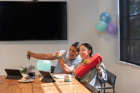 Coworkers Celebrating Birthday with Gift in Meeting Room