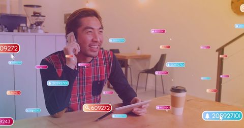 Smiling Man Engaging with Social Media in Coffee Shop