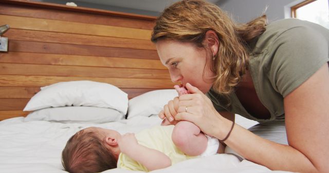 Image of happy caucasian mother kissing feet of newborn baby - Download Free Stock Photos Pikwizard.com