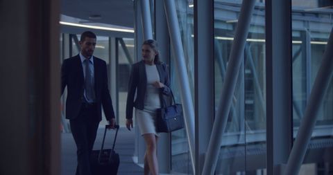 Business Colleagues Walking With Luggage in Airport Corridor